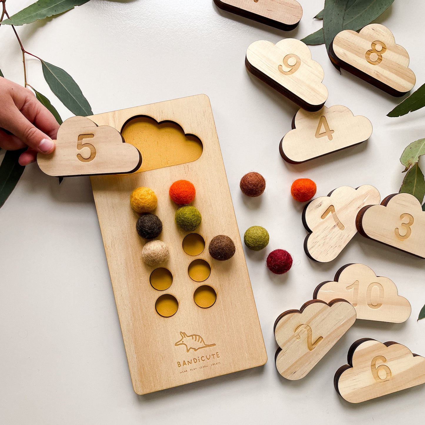 Child using ten frame counting board with  earthy felt balls