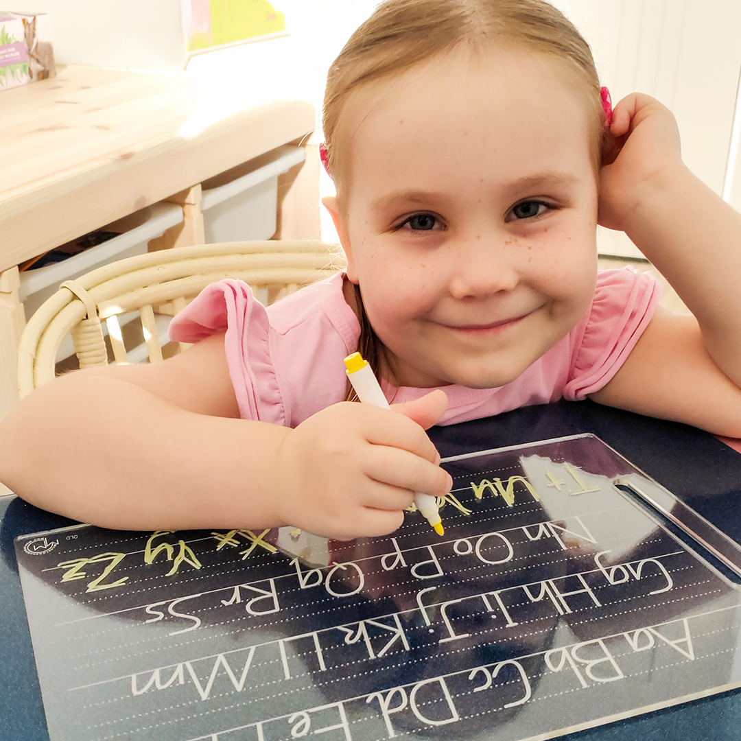 Girl smiling while using Alphabet Tracing Board