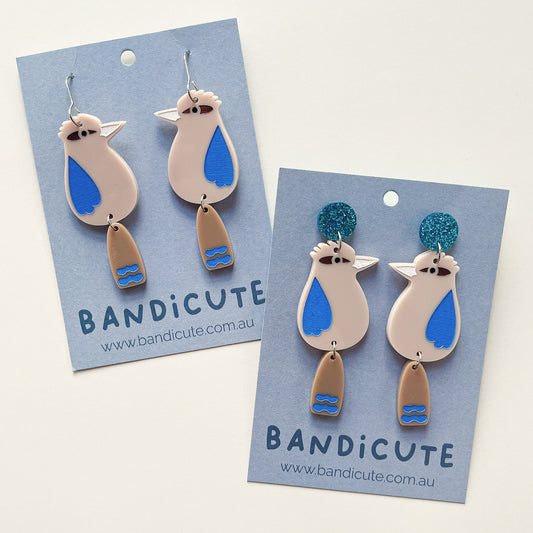 Mini kookaburra dangle earrings. Beige with brown tails, blue painted features.