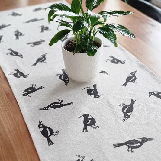 Magpie table runner with potted plant in white pot
