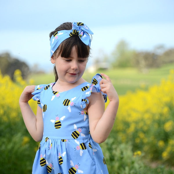 Young girl wearing blue bee dress